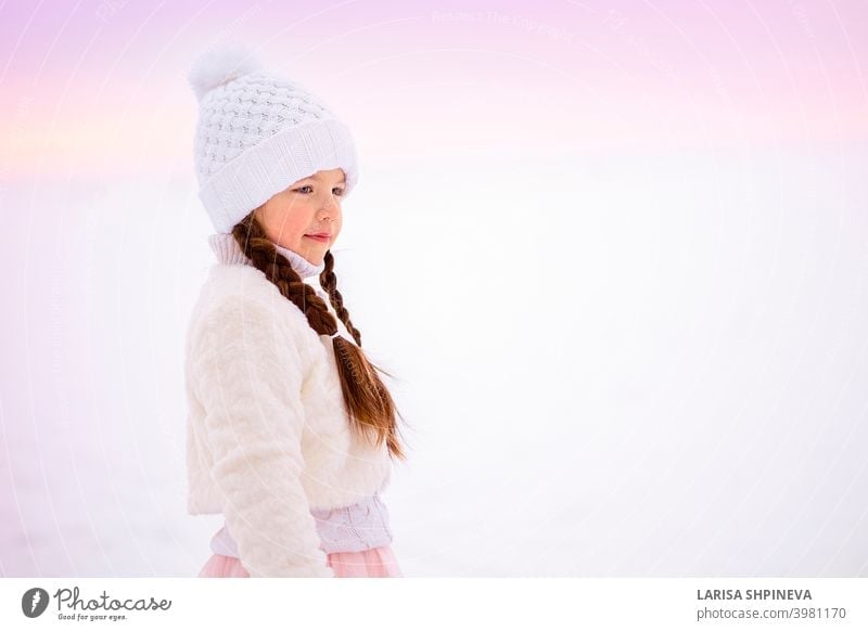 Portrait of little girl on walk in winter in early frosty morning. cold face hat beautiful young snow christmas portrait cute happy fashion white outdoor people
