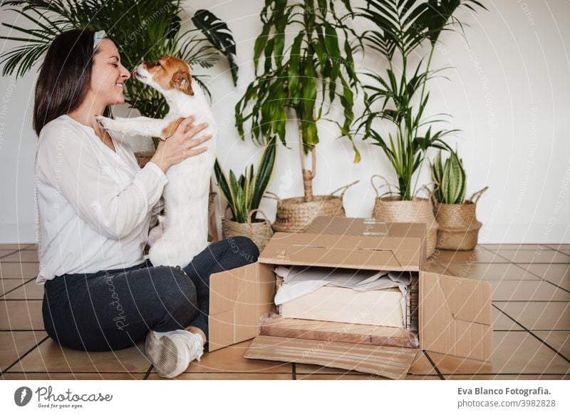 happy woman and dog relaxing at home after working assembling furniture. DIY concept. woman kissing dog. love do it yourself hug together owner jack russell