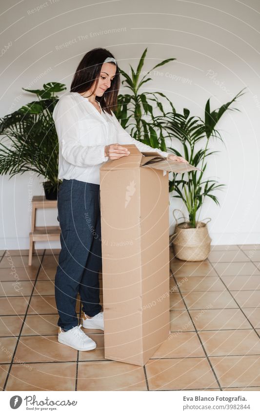 close up of young woman assembling furniture. Unboxing pieces from carton box. DIY concept do it yourself home house caucasian indoor working renovation