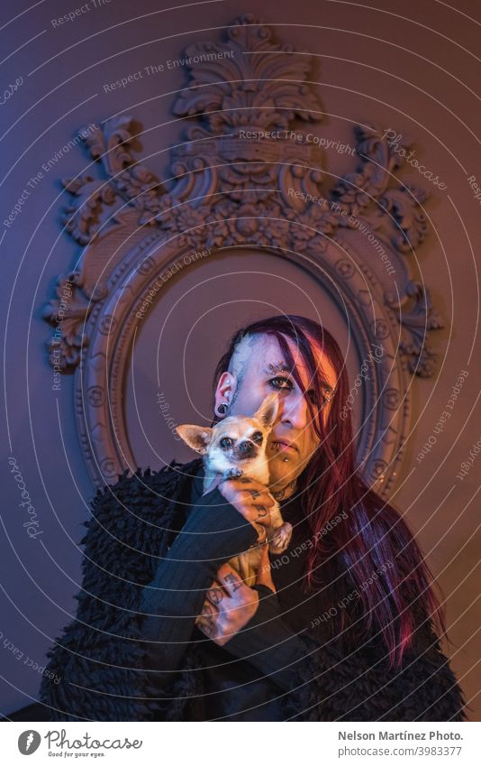 Framed portrait of an eccentric rocker with his little dog. He has long purple hair. androgynous male beautiful young man feminine guy closeup gay photogenic