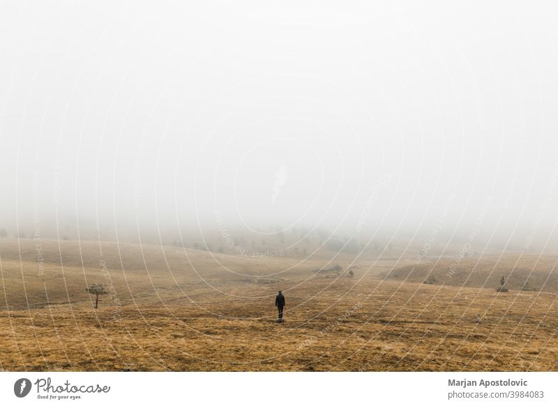 Young man exploring nature on a wet winter morning in the mountains - a  Royalty Free Stock Photo from Photocase