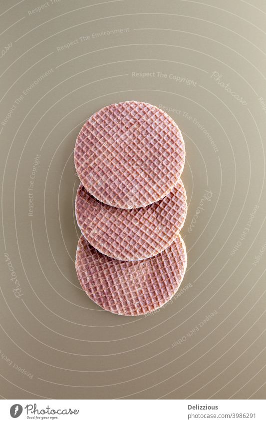 Three traditional Dutch stroopwafels (syrup or caramel waffles) on a golden background, copy space bake biscuit brown bunch butter circle closeup cookie