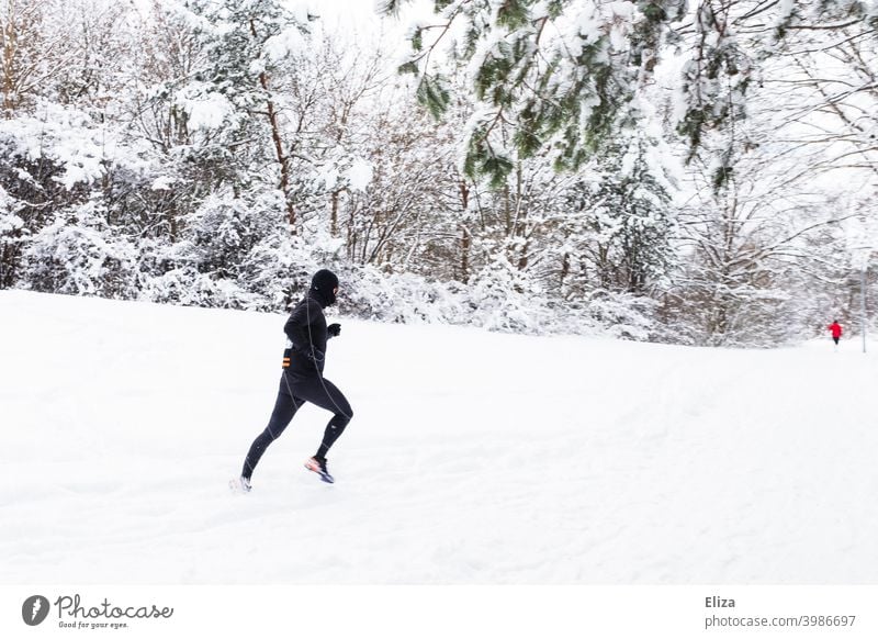 A man jogs through the snow in winter - a Royalty Free Stock Photo