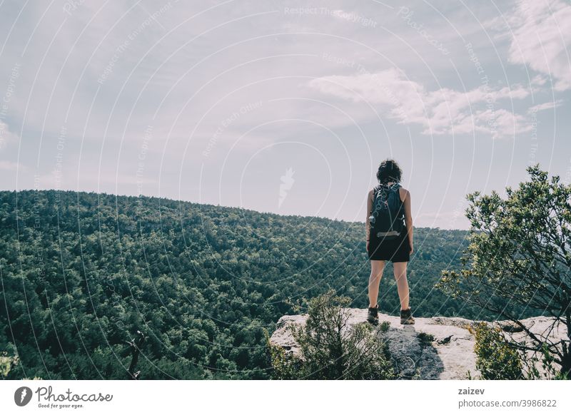Girl who has gone hiking looking at the landscape on a hill on a summer day la febró prades catalonia spain outdoor medium copy space color people female