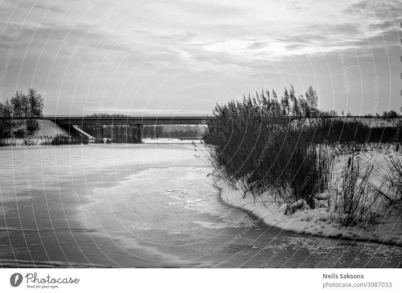 nice cloudy sky over the bridge over frozen river in sunset architecture autumn construction dark day embankment footbridge high rise landscape modern nature