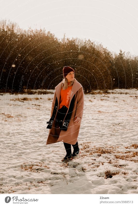 Fashionably dressed young woman walking in light snowfall stroll Winter wonderland Woman Young woman Coat To go for a walk Snow Sun Light Nature Landscape Scarf