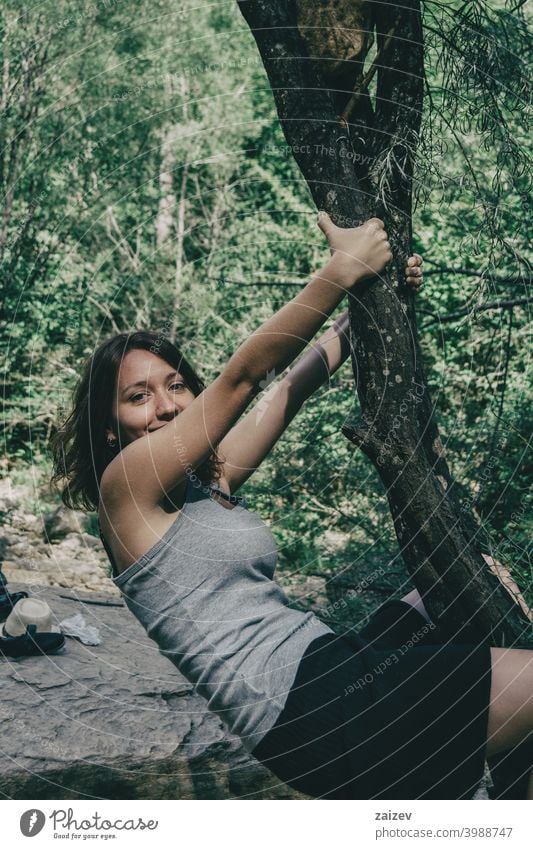 girl hanging from a tree laughing agility humor tranquility youth vitality person happiness smiling one person young adult joy playing expression looking