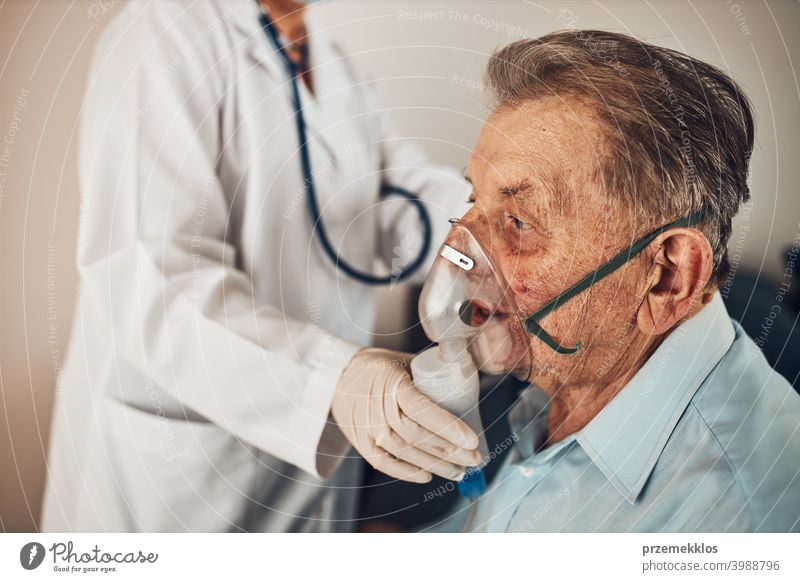 Doctor applying a medicine during inhalation to senior man suffering from lung disease. Covid-19 or coronavirus treatment patient person hospital medical