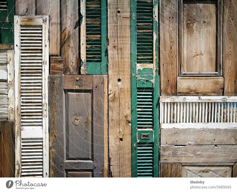 Decorative wall of old wooden doors and shutters in an open-air bar in the old town of Alacati on the Mediterranean Sea near Izmir in Turkey background Wood