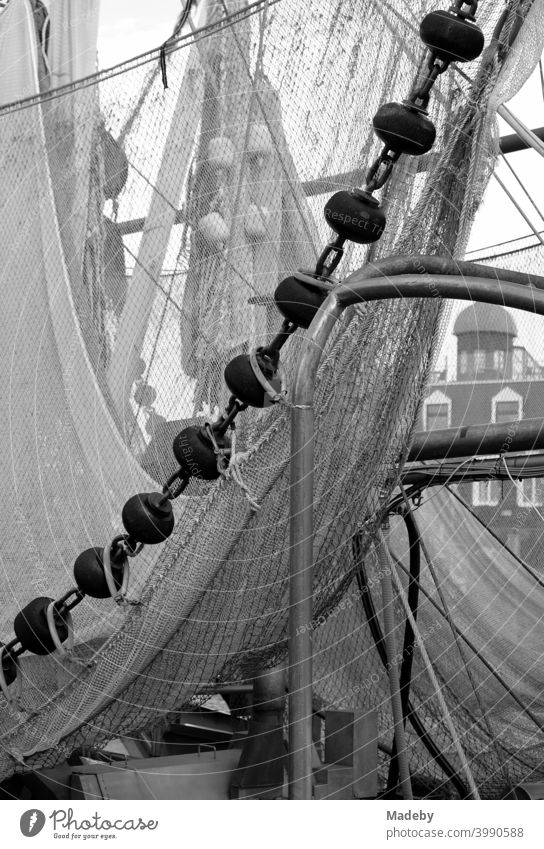 Fishing nets of an old fishing cutter in the harbour of Neuharlingersiel at the North Sea coast near Esens in the district of Wittmund in Lower Saxony, photographed in classic black and white