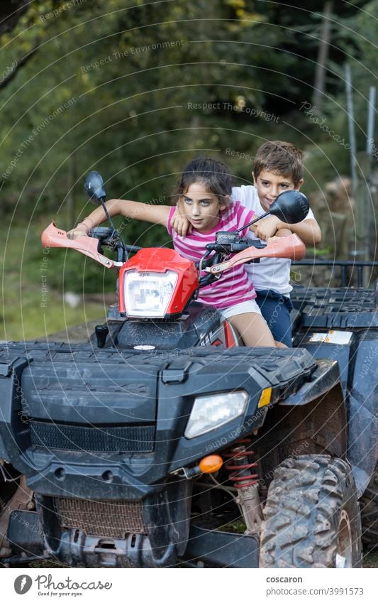 Two little kids riding a quad active activity adventure bike boy brother car child childhood children drive driver emotion freedom friendship fun game girl