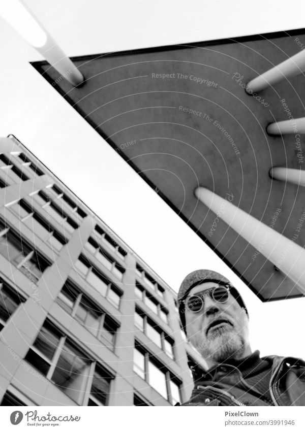 An old man stands between two skyscrapers and looks at the sky Man Face Eyeglasses Looking Facial hair Head portrait Architecture Building City