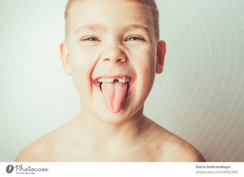 Funny boy with no tooth shows tongue little child care male person background mouth face portrait childhood funny teeth happiness white beautiful smile without