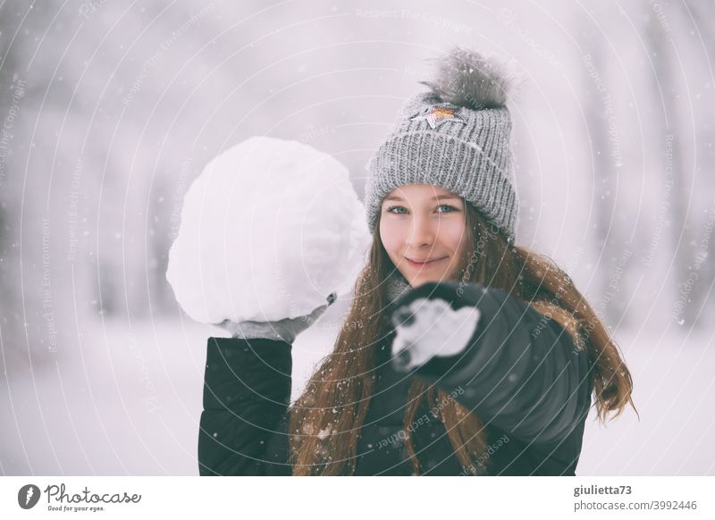 Happy naughty teen girl in winter with huge snowball Winter Snow White Bobble hat Feminine Subdued colour snowflakes snowy Long-haired 13 - 18 years