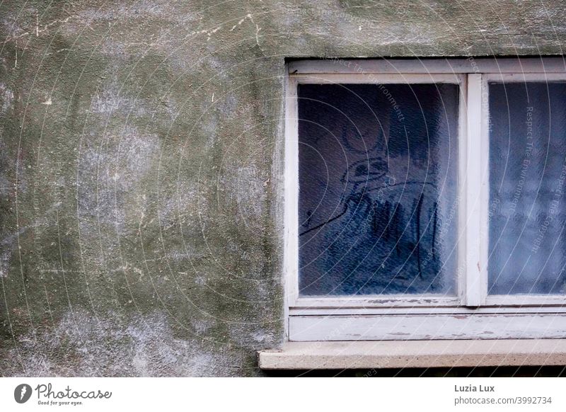 In the window of an old vacant house an old curtain and faces, ghosts scrawled in the dust house wall Window Old Gloomy frowzy Dusty Windowsill Window pane