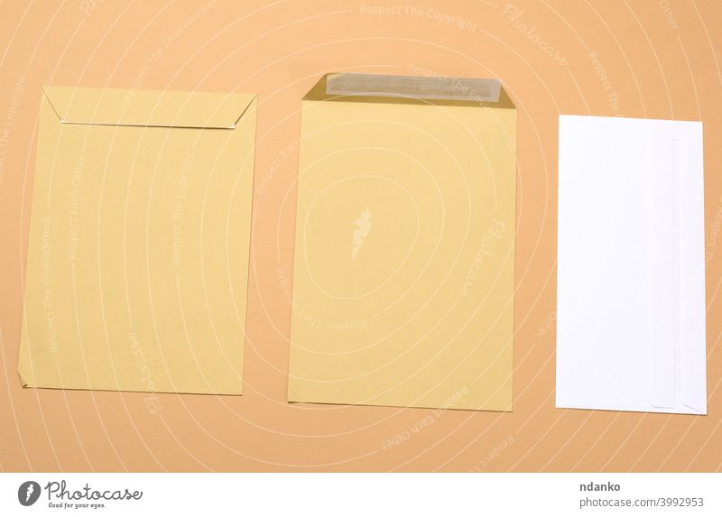 blank white paper brown and white envelopes on a brown background letter empty message office post card document mail postage stationery delivery communication