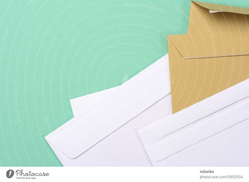 blank white paper brown and white envelopes on a green background letter empty message office post card document mail postage stationery delivery communication