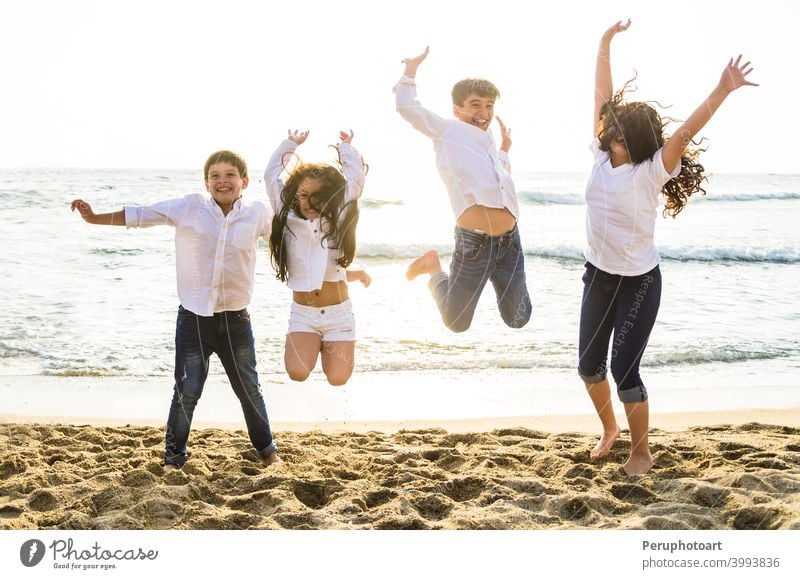 Happy kids jumping together on the beach children sea people family water summer sky sunlight happy group sunset vacation travel joy boy girl holiday fun young