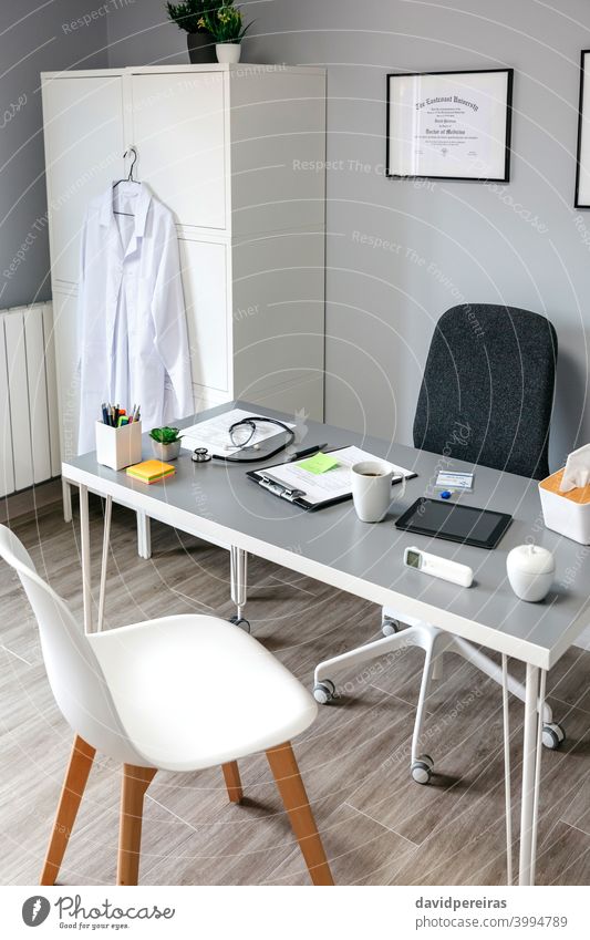 Interior of empty doctor's office interior doctors office nobody white coat consultation clinic tablet hospital medicine room office chair wheels desk