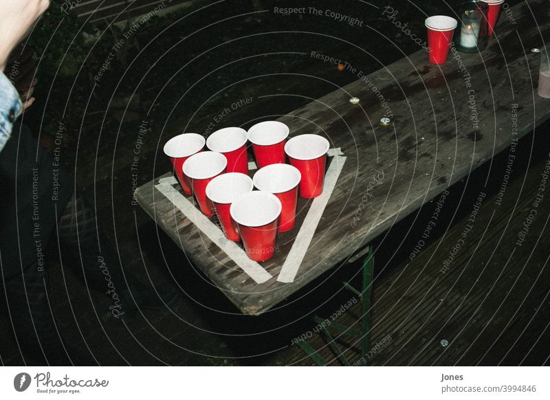 Outdoor beer pong game Beer Beer Pong out Mug Table Tennis Ball Ale bench Red Black Retro Hipster fun Joy Free Freedom Night night at night Evening Dark