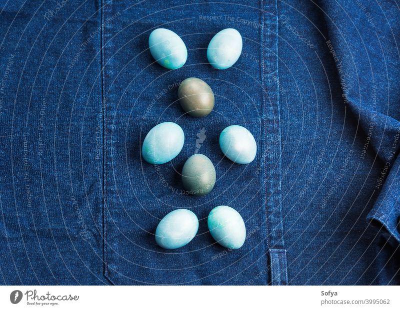 Blue colored easter hard boiled eggs on denim apron bunny blue spring shape texture pattern dark background fabric design jeans textile indigo funny happy