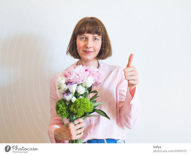 Woman in pink holding beautiful bouquet with hand thumbs up woman approve yes support local shopping mother day mothers day flowers spring face lifestyle