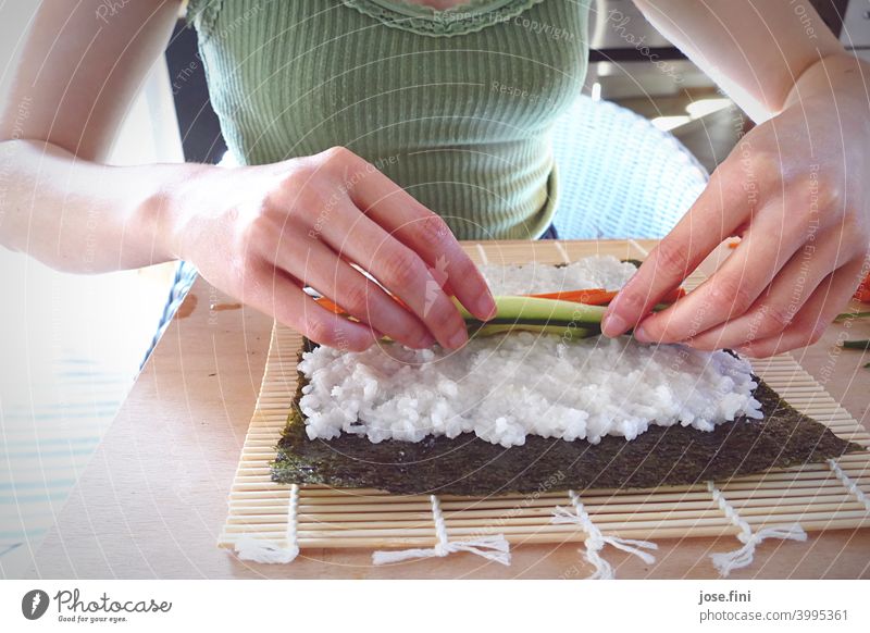 Hands of a woman preparing sushi by herself hands Upper body Sushi Eating preparation Kitchen Rice Salmon Japanese Asian Food traditionally Wasabi Ginger