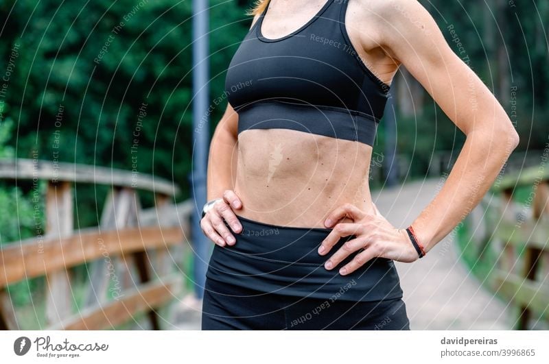 Athlete woman posing with sportswear sportswoman midsection top slender flat stomach abs unrecognizable healthy athlete training skin moles arms hands