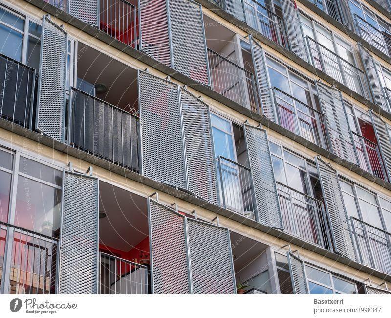 Detailed view of a modern residential building with balconies and hinged metal shutters Apartment Building dwell Modern High-rise Red Colour Glass Metal Load