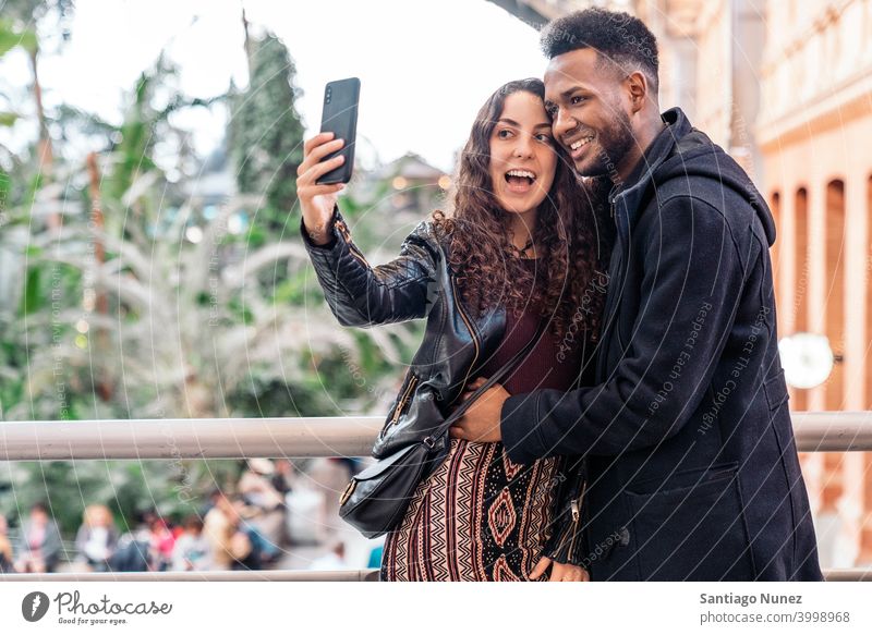Love Couple taking a selfie couple relationship taking selfie front view interracial couple black man afro african american love cell cell phone cellphone city