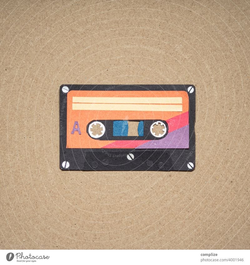 old audio technology, compact music cassette with text - disco, on a large  amount of magnetic tape. Magnetic tapes background, realistic retro design  - a Royalty Free Stock Photo from Photocase