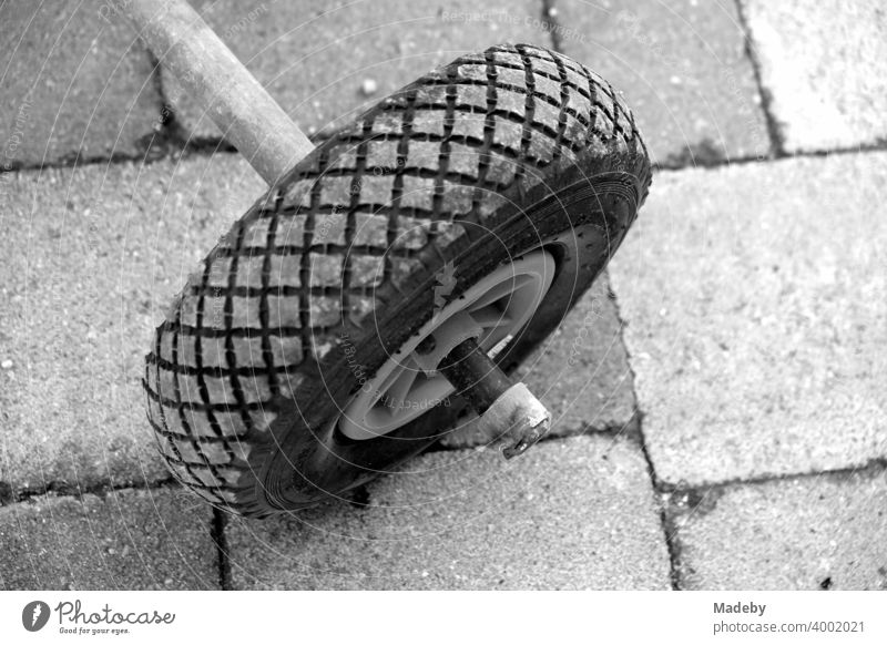 Wheel of an old sack barrow on a self-made tricycle on a farm in Rudersau near Rottenbuch in the district Weilheim-Schongau in Upper Bavaria, photographed in classic black and white