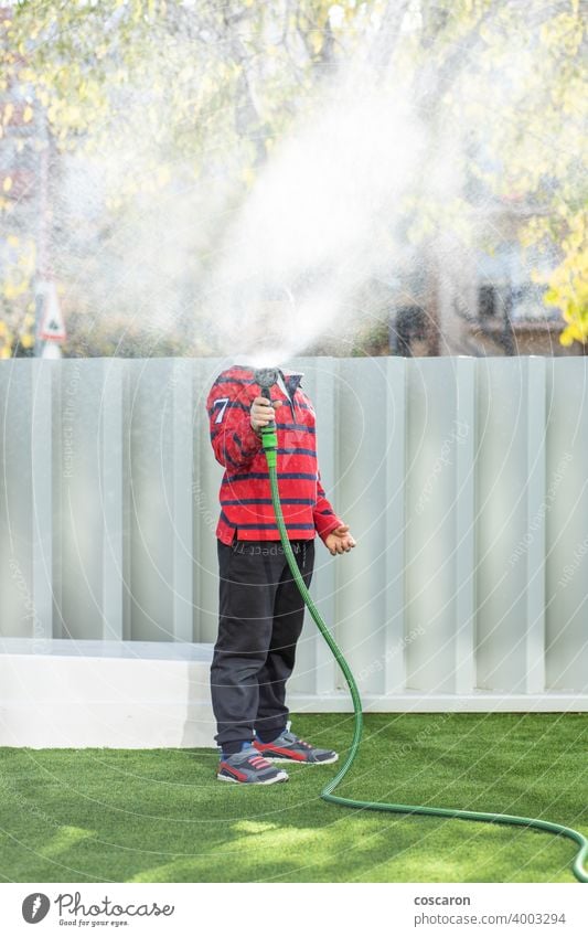 Little boy watering the grass in the garden action activity child childhood children drops enjoy family fountain fresh fun gardening green happiness happy hose