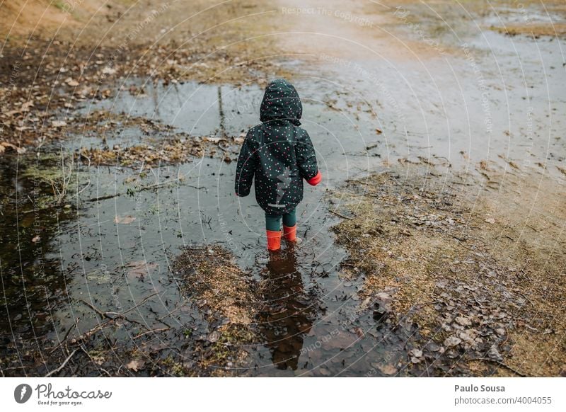Child with red rubber boots playing on a puddle Rubber boots Red childhood Girl Water Human being Boots Playing Rain Puddle Dirty Day Copy Space bottom Toddler