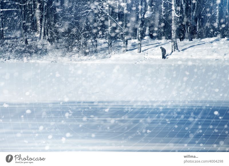 A cold winter day with snowflakes, lonely person in background - a