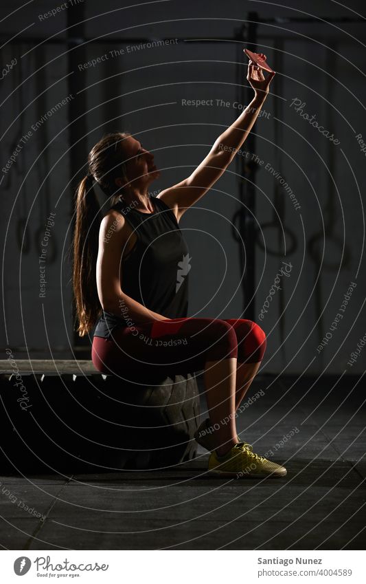 Woman sitting down and taking a selfie. crossfit functional training gym health sport fitness workout lifestyle healthy adult vitality sportswear room isolated