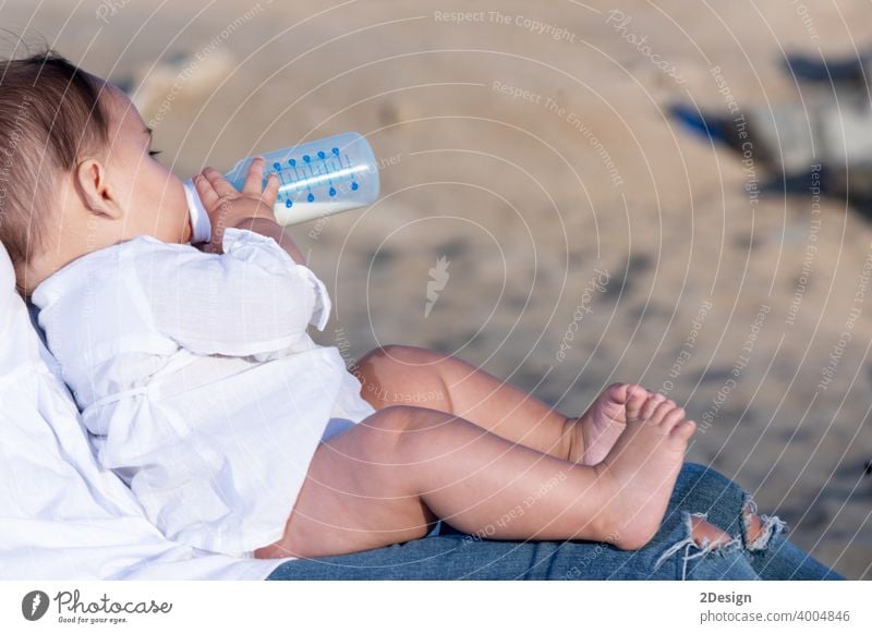 https://www.photocase.com/photos/4004846-newborn-drinking-milk-from-a-baby-bottle-sitting-on-mom-legs-outdoors-photocase-stock-photo-large.jpeg