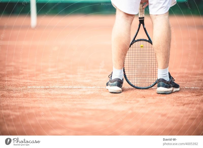 Man standing casually with a tennis racket on the tennis court Tennis Tennis court Sports Sportsperson Easygoing Cool Tennis rack Athletic Leisure and hobbies