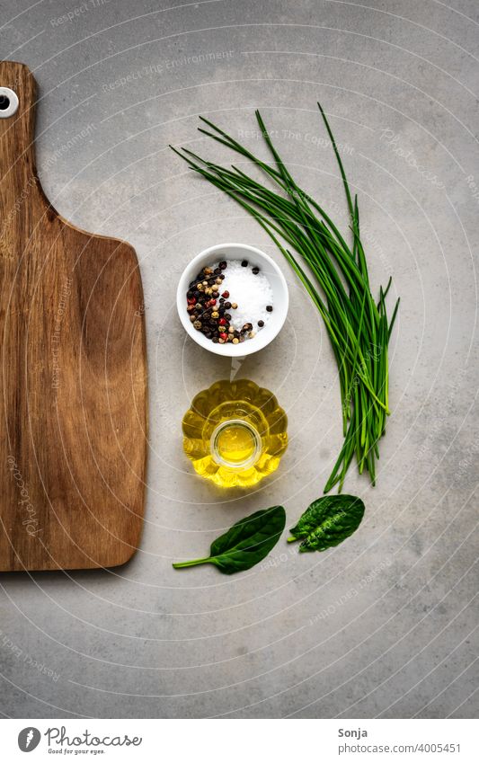 Fresh herbs, olive oil, salt and an empty wooden chopping board on a rustic table. Herbs and spices Chopping board Wood Empty Olive oil Salt Ingredients Food