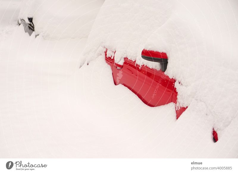 Masses of snow are lying on a red and a black car, so that only little of them can be seen / snowed in / onset of winter / fresh snow Snow Snow masses