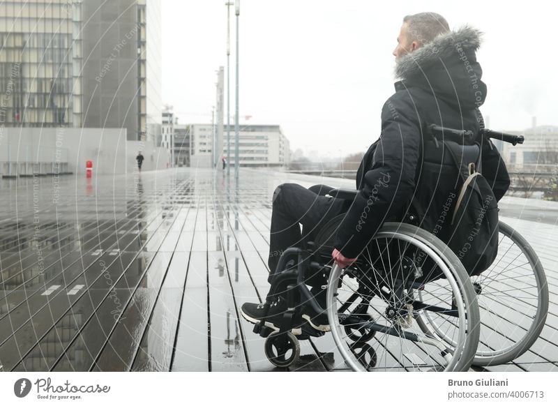 Concept of disabled person. A man in a wheelchair outside in the street. medical paraplegic disability equipment handicapped transportation mobility