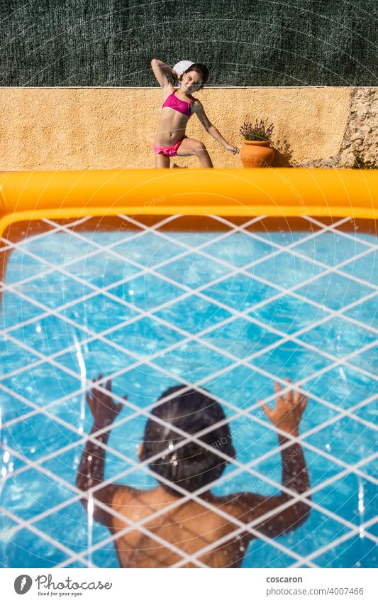 Two kids playing with a ball on a pool active activity aquatic beach blue boy caucasian child childhood children energy family fun game girl goal guy happy