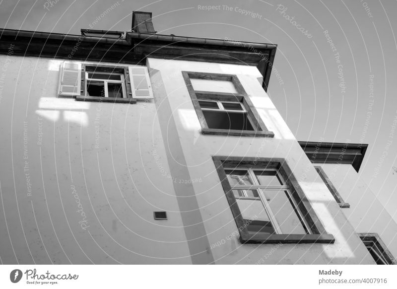 Facade of an old building from the frog perspective in a backyard in summer sunshine in the Westend of Frankfurt am Main in Hesse, photographed in classic black and white