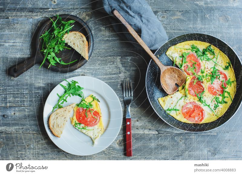 tasty italian style vegetarian breakfast - fried eggs frittata ot omelete with mozarella cheese, arugula and tomatoes vegetable food healthy lunch closeup