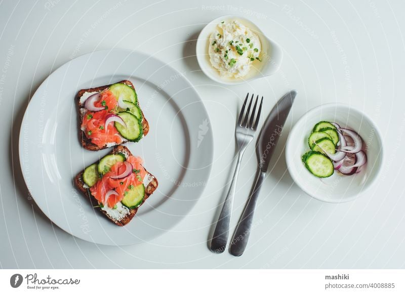 tasty healthy breakfast - salmon and avocado toast with cream cheese, cucumber and red onion on white background food sandwich bread snack meal fish lunch