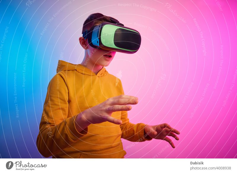 Boy with virtual reality glasses on colorful background. Future technology, VR concept vr headset boy helmet device game future video experience wearable