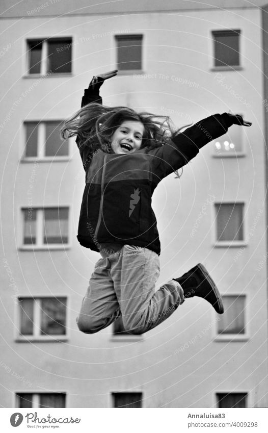 joyful leaps Jump Hop Girl Winter Cold Joy Tall Black & white photo Long-haired Child Infancy Anticipation Dance Happy fortunate yeah Skip