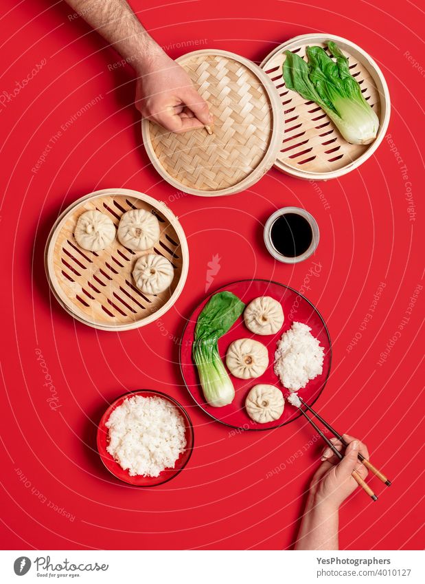 Bao dumplings and bok choy, flat lay. Eating traditional steamed chinese food asian bamboo steamer bao dumplings baozi basket bun chopsticks colored background