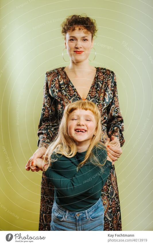 portrait of single mother and her pre-teen daughter against green background adult care caucasian cheerful child childhood cute emotion family female females