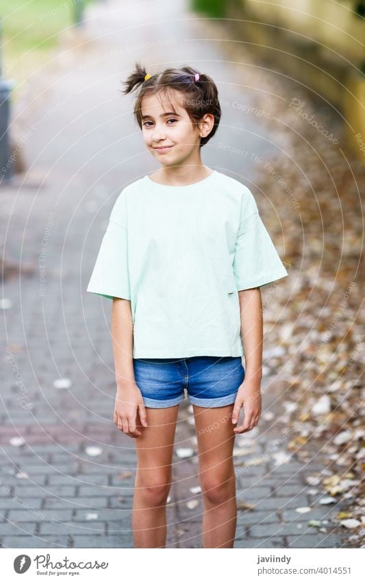 Back view of little child girl in white t-shirt, jeans shorts and